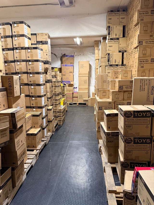 Corredor despejado con cajas apiladas a ambos lados sobre tarimas