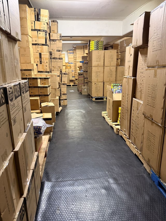 Corredor amplio entre grupos de cajas acomodadas sobre distintas tarimas
