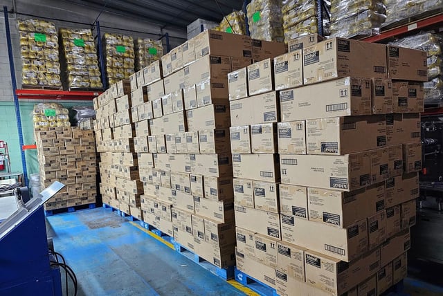 Gran agrupación de cajas sobre tarimas bajo varios niveles de estantería